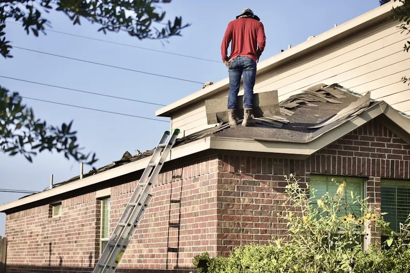 Professional roofer working on a residential roof in Fairfax Forest